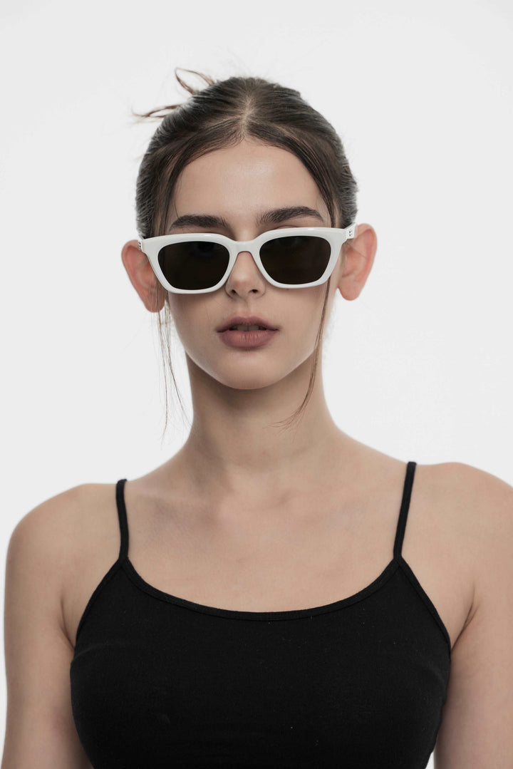 Female Model of her front face wearing Burr Puzzle’s Shadow in white square stylish sunglasses with UV protection from Mercury Retrograde  