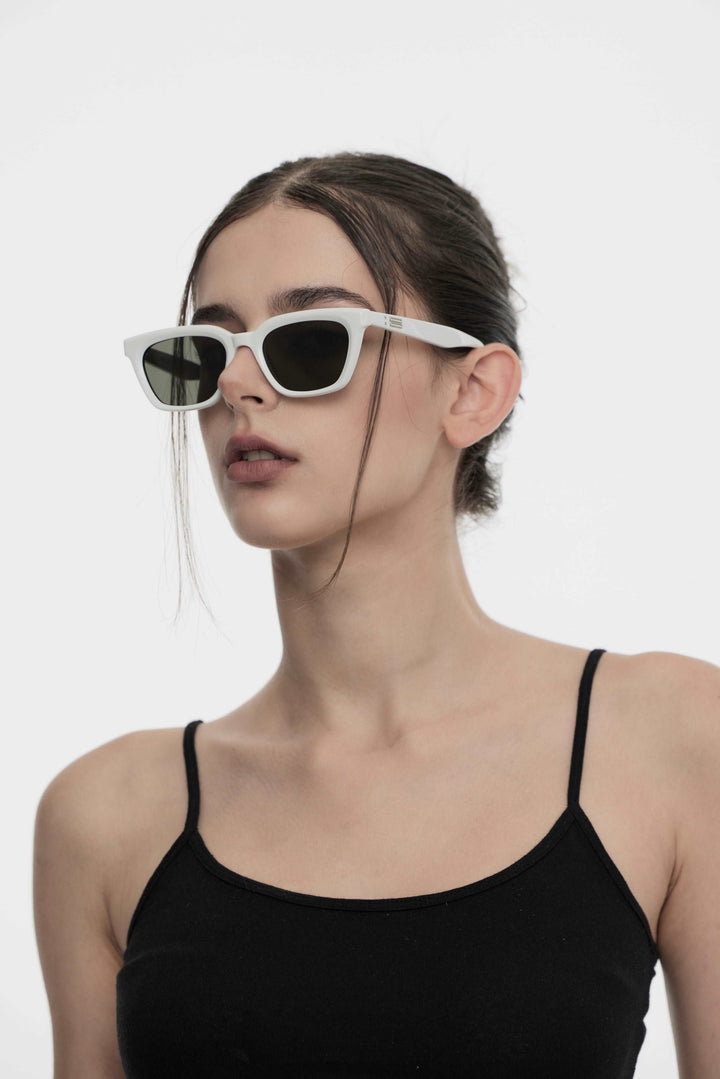 Side portrait of model illustrating the stylish design of Burr Puzzle's Shadow in white square Sunglasses by Mercury Retrograde