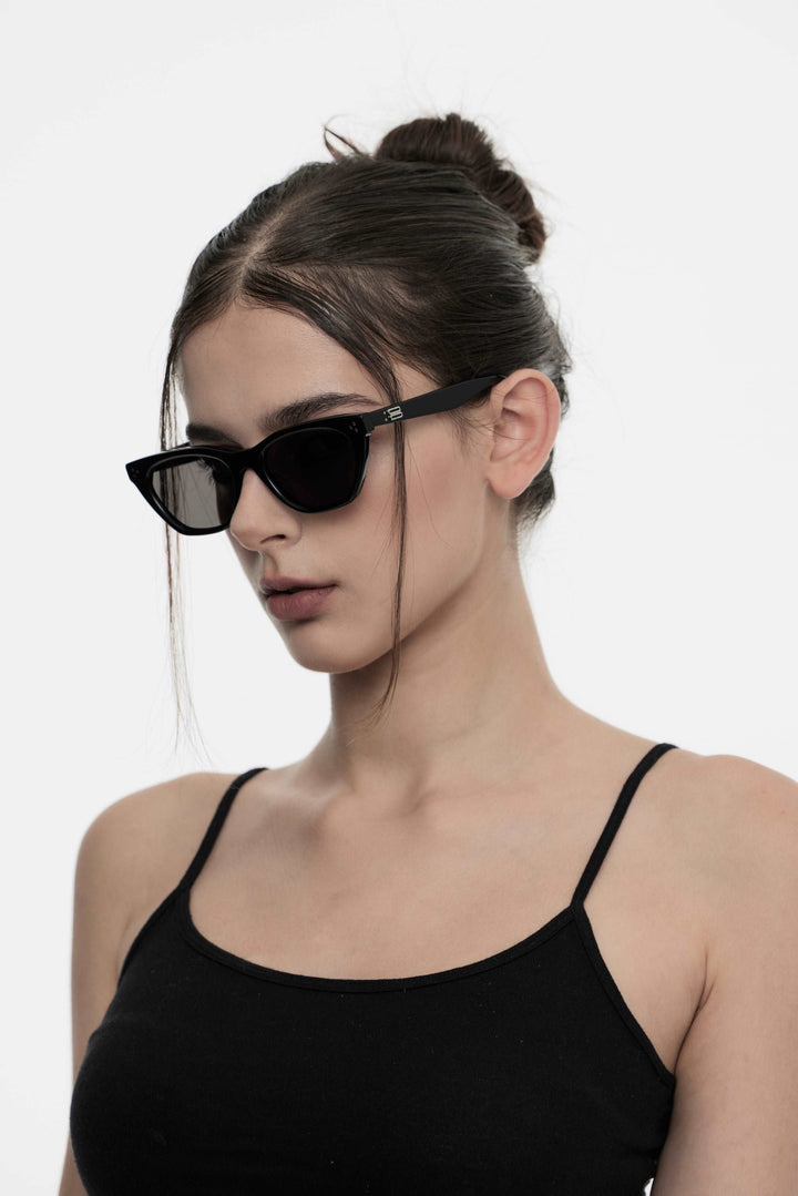 Model of her side face looking down wearing Artist Kpop Dex in black cat-eye Sunglasses from Mercury Retrograde Burr Puzzle Collection 