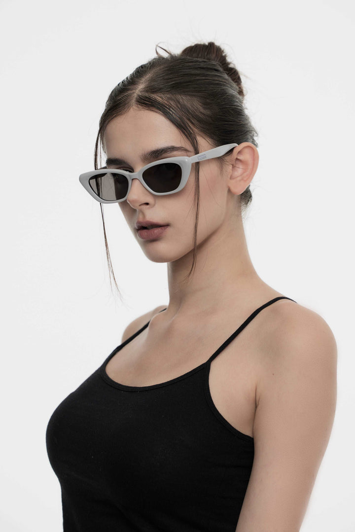 Model of her side face looking down wearing California in grey cat-eye Kpop Sunglasses from Mercury Retrograde Burr Puzzle Collection 