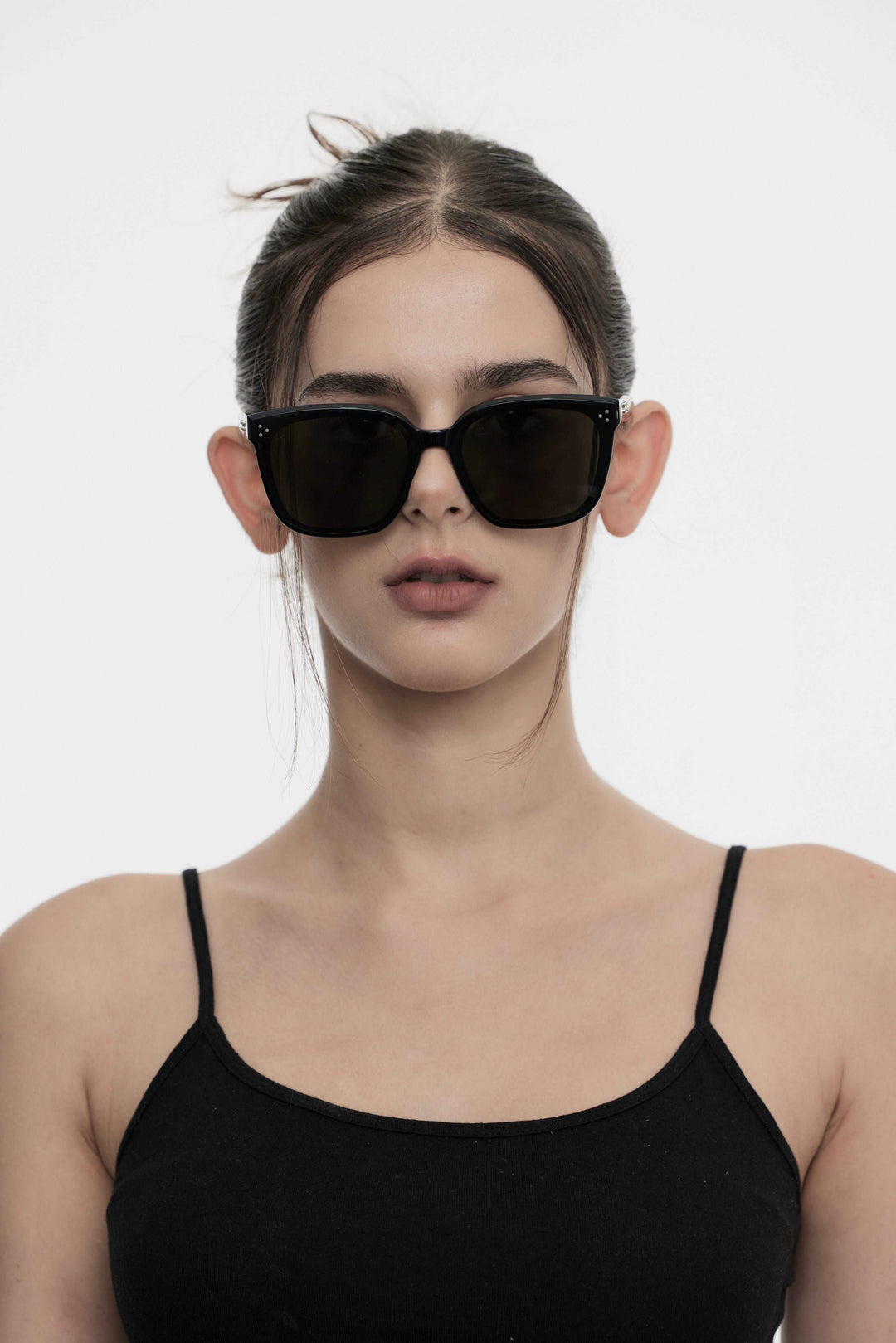 Female Model of her front face wearing Indulge in black square sunglasses with UV protection from Mercury Retrograde Burr Puzzle Collection 