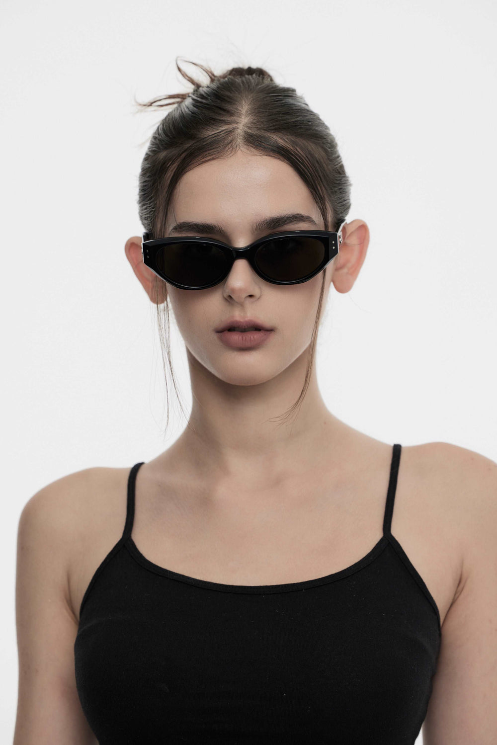 Female Model of her front face wearing Symphony in black cat-eye fashion sunglasses from Mercury Retrograde Burr Puzzle Collection 