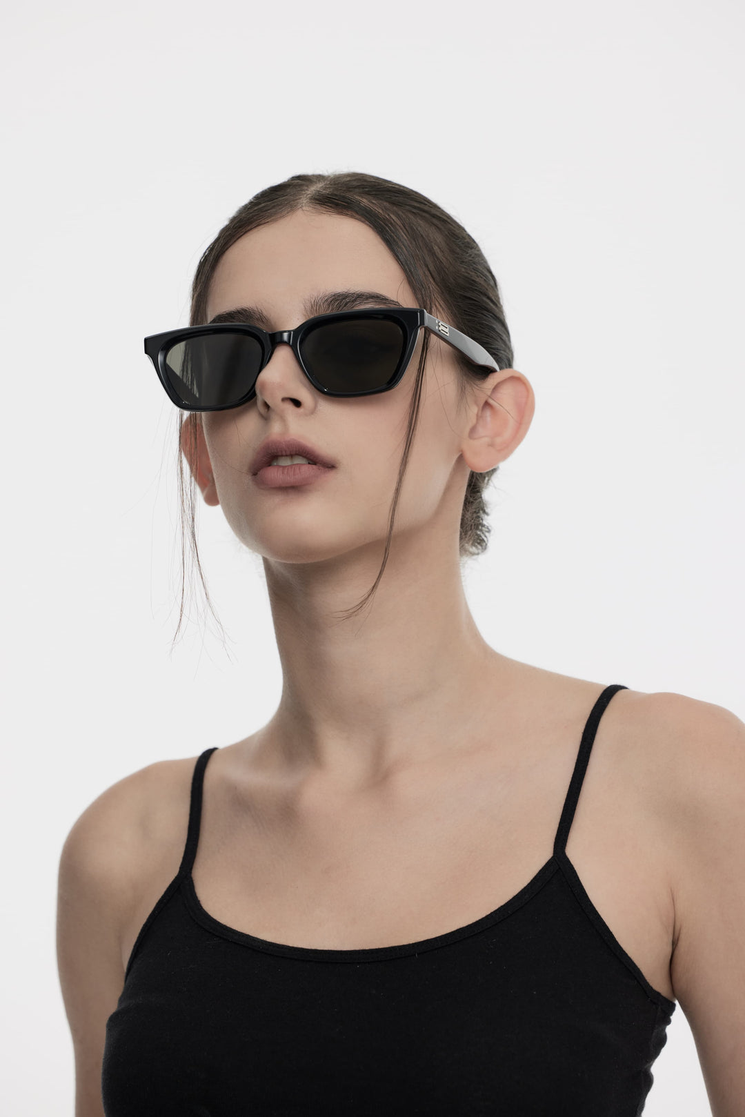 Model of her side face looking up wearing Shadow in black square Kpop Sunglasses from Mercury Retrograde Burr Puzzle Collection 