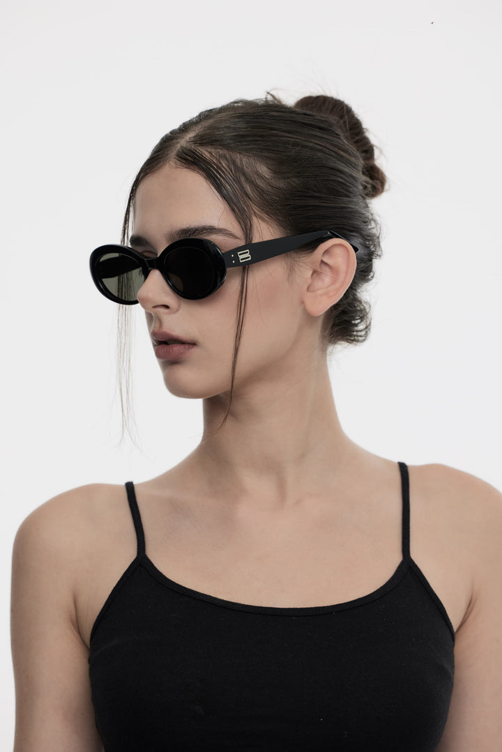 Side portrait of model illustrating the trendy design of Burr Puzzle's Poison in black round Sunglasses by Mercury Retrograde