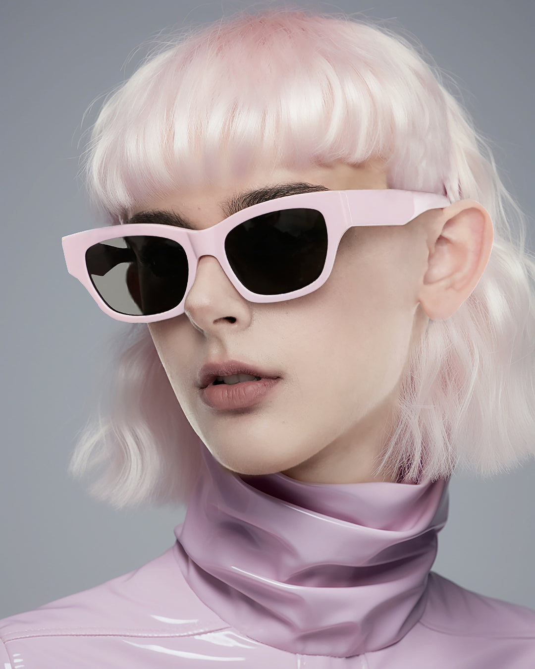 A stylish lady wearing mercury retrograde sunglasses flaunting vibrant pink locks and trendy shades exudes an air of sophistication and individuality.