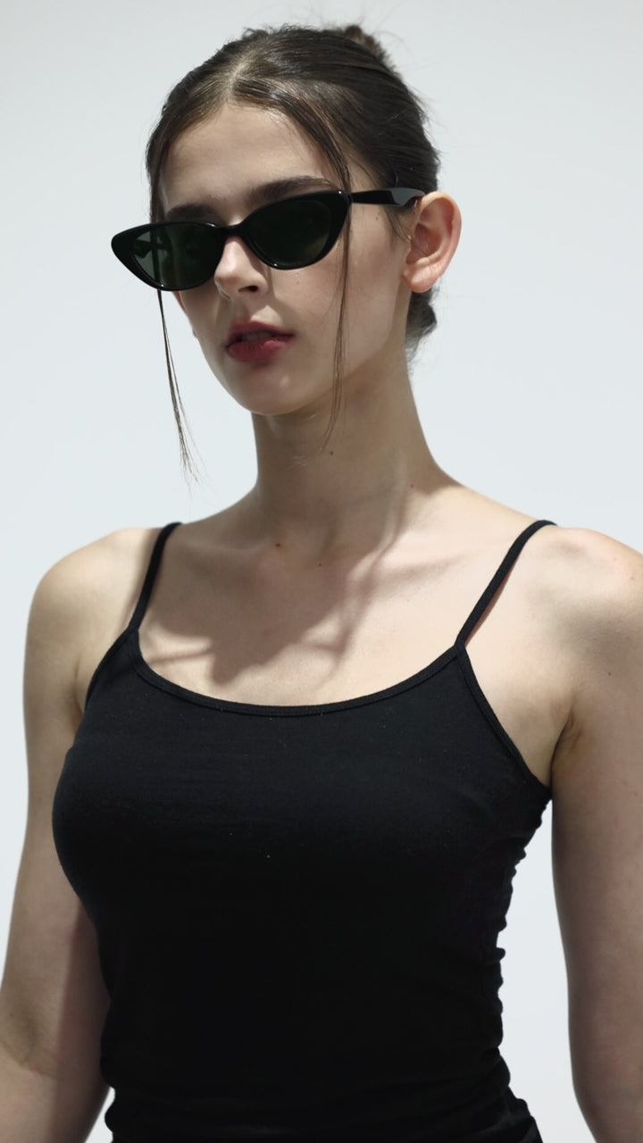 Walking model wearing Dawn in black cat-eye fashion Sunglasses from Mercury Retrograde Daydream Collection 