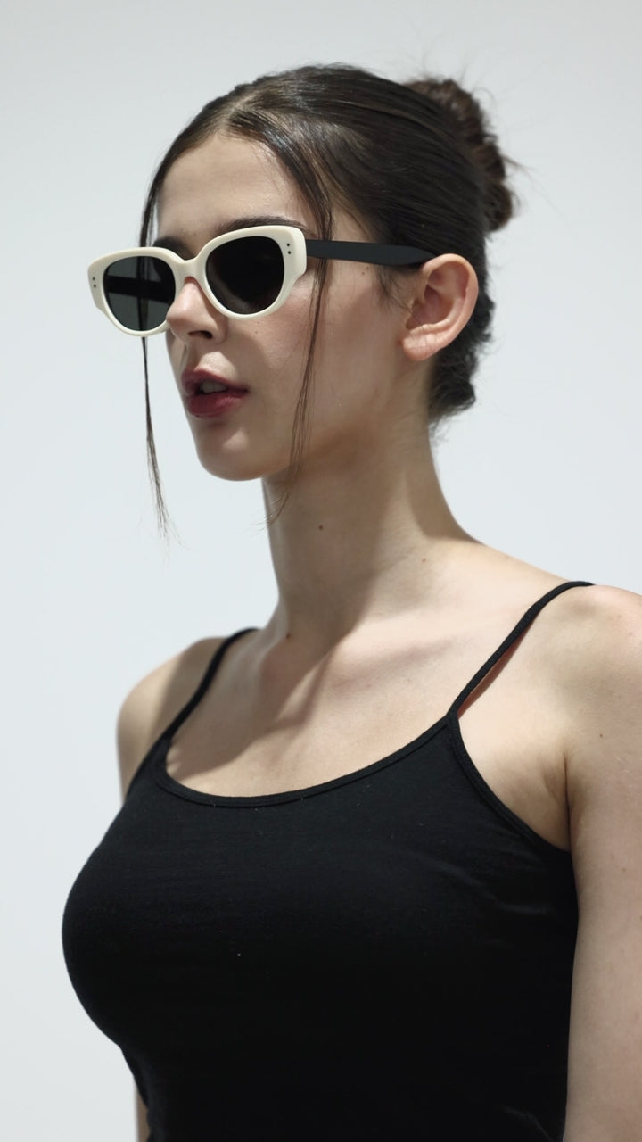 Walking female model wearing her Panda in black&white round stylish Sunglasses from Mercury Retrograde Daydream Collection 