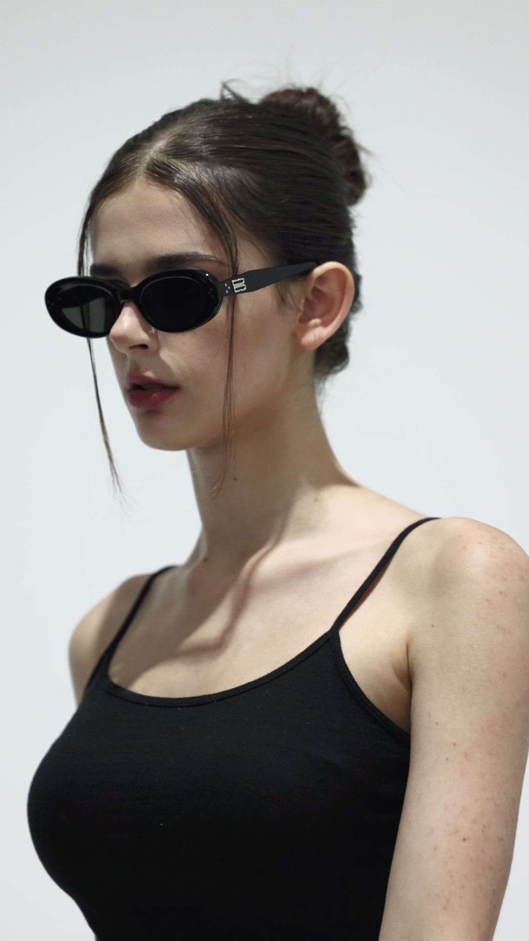 Walking model wearing her Breath in black Designer round Sunglasses from Mercury Retrograde Burr Puzzle Collection 