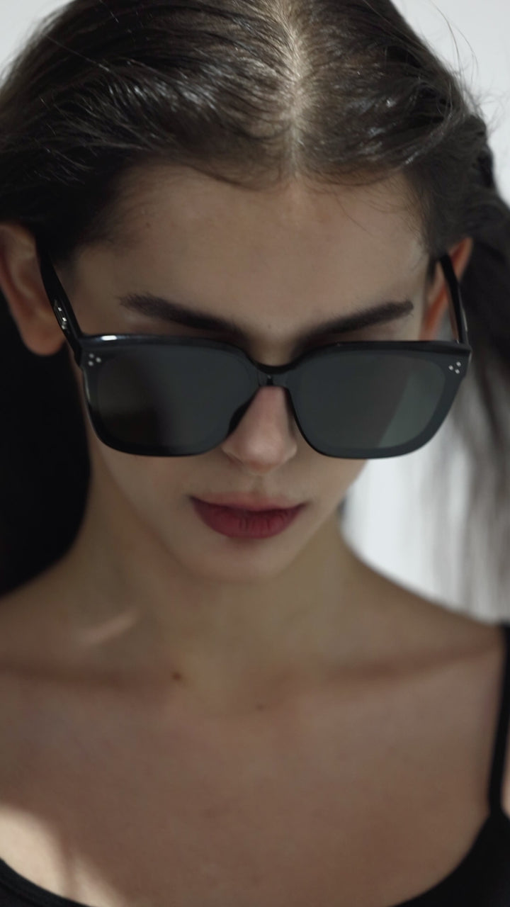 Walking model wearing Indulge in black square Designer Sunglasses from Mercury Retrograde Burr Puzzle Collection 