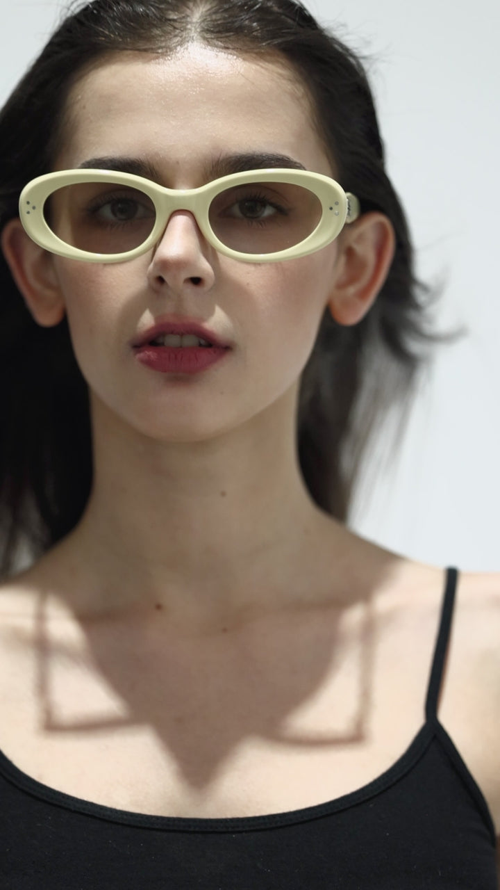 Walking model wearing Burr Puzzle’s Breath in light yellow trendy round Sunglasses from Mercury Retrograde