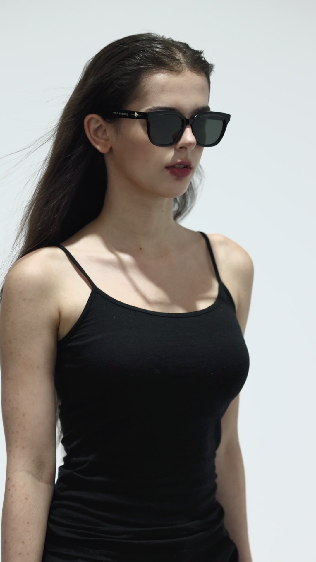 Walking female model wearing her Galaxy’s Cygnus in black square fashion Sunglasses from Mercury Retrograde