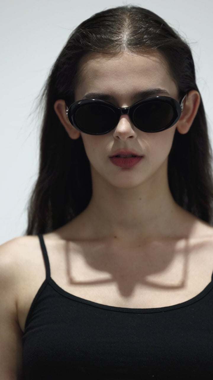 Walking model wearing Poison in black round Designer Sunglasses from Mercury Retrograde Burr Puzzle Collection 