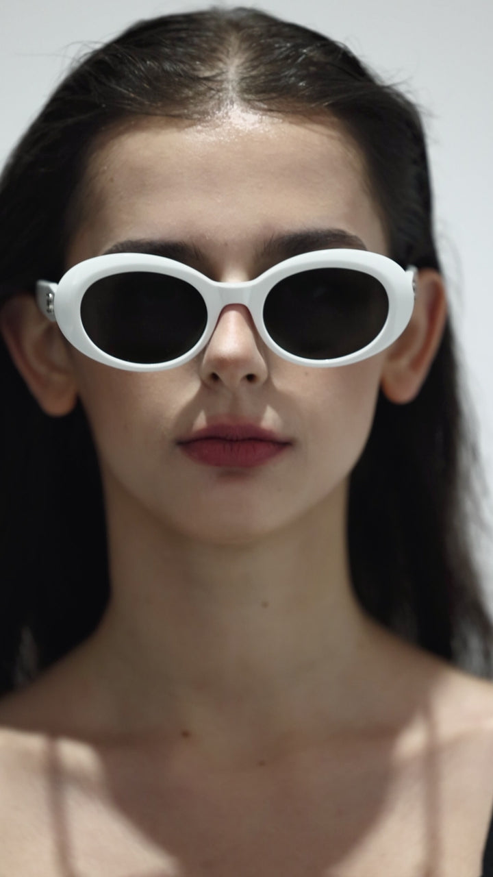 Close-up of walking model wearing Burr Puzzle’s Poison in white round  Designer Sunglasses with UV protection from Mercury Retrograde  