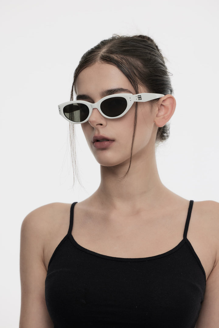 Side portrait of model illustrating the stylish design of Burr Puzzle's Symphony in white cat-eye Sunglasses by Mercury Retrograde